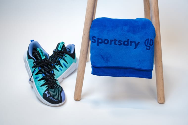 Blåt håndklæde lagt over en skammel ved siden af et par sneakers