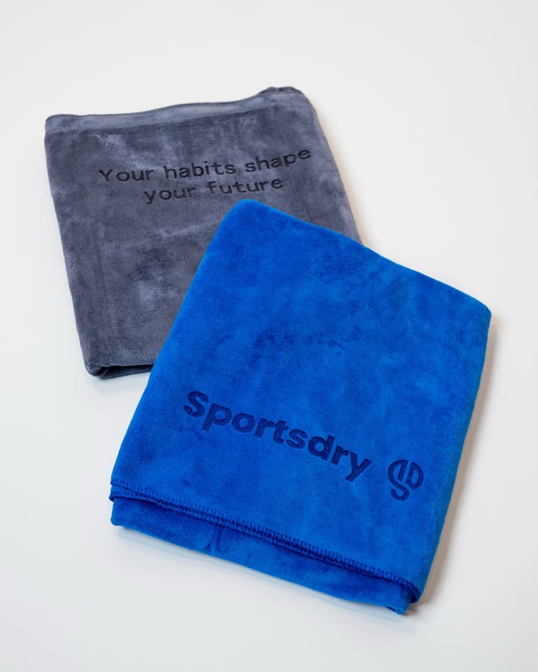 Det blå og det grå Sportsdry-håndklæde stablet oven på hinanden